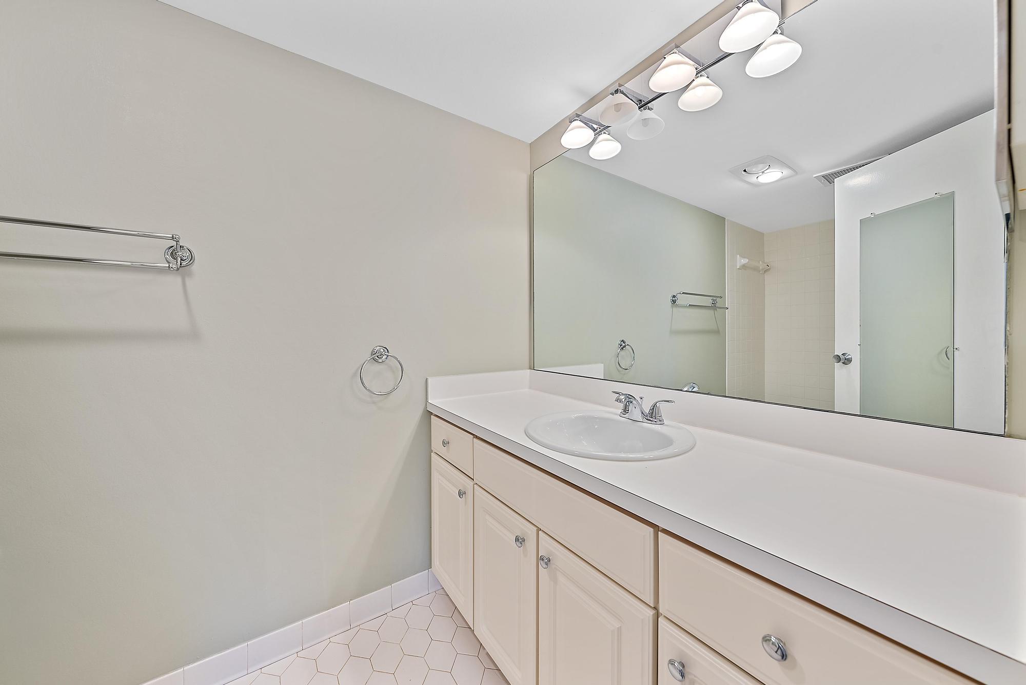 1208 Marine Way, Unit 105 North Palm Beach, FL 33408 - Photo 17 of 22 a bathroom with a sink a vanity and a mirror