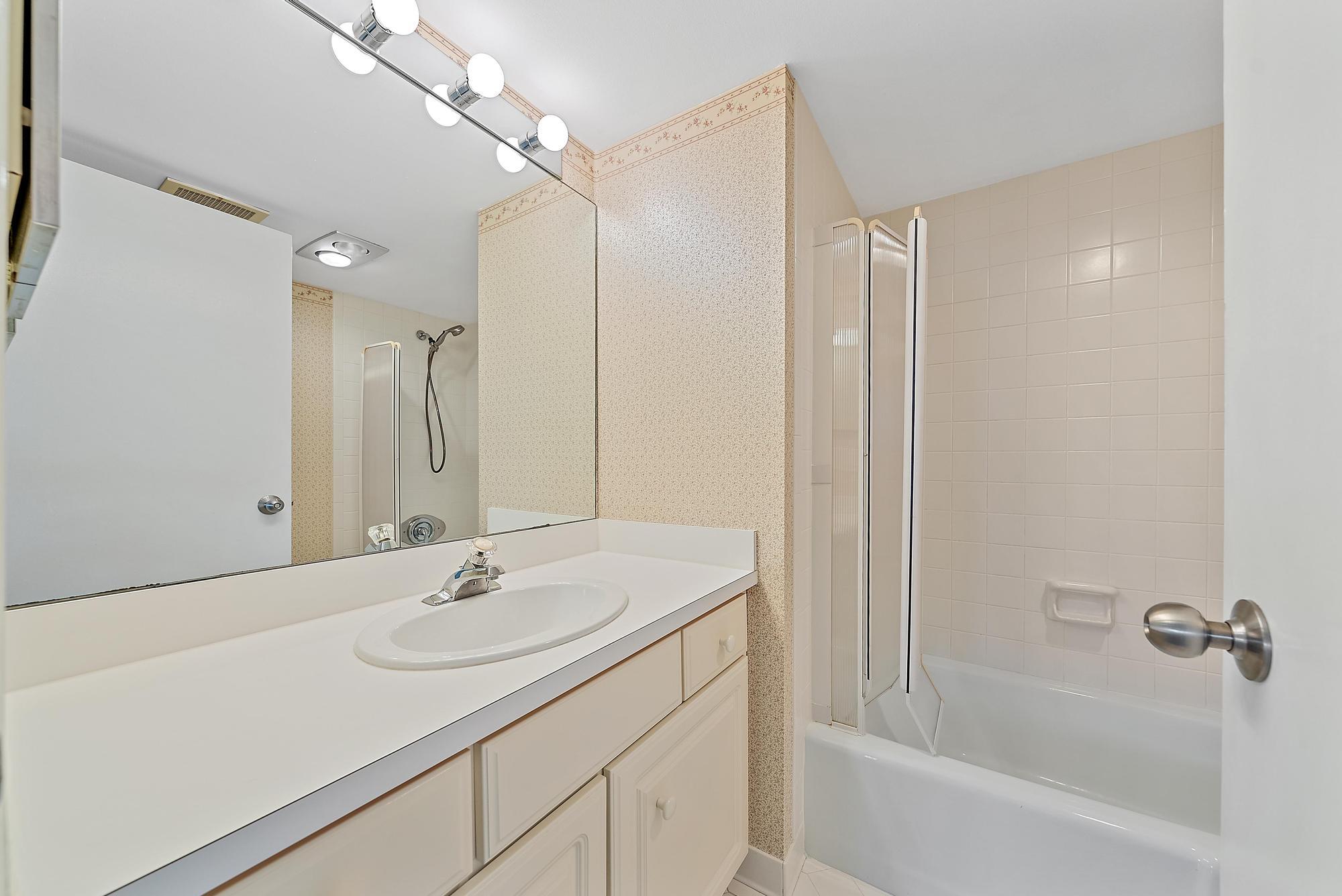 1208 Marine Way, Unit 105 North Palm Beach, FL 33408 - Photo 18 of 22 a bathroom with a sink double vanity mirror and a bathtub