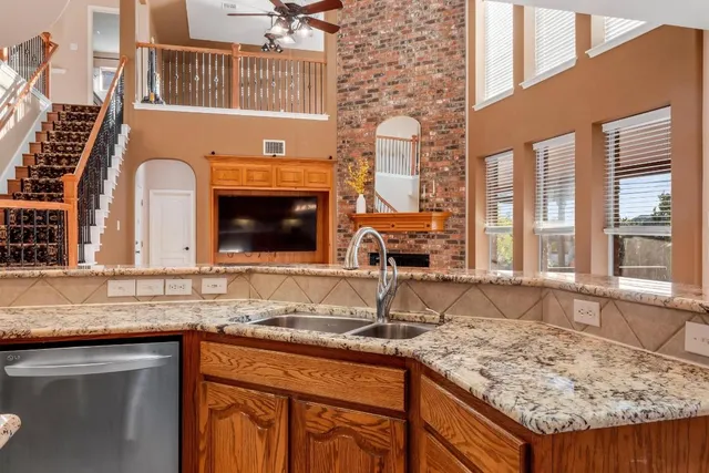 a kitchen with granite countertop a sink and a wooden cabinets