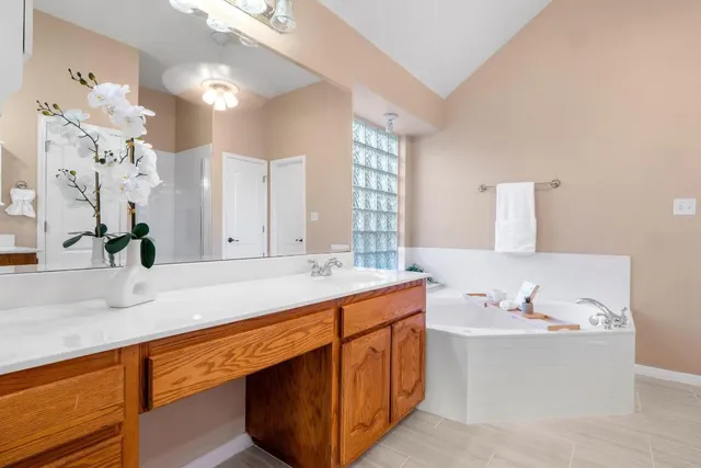 a bathroom with a tub sink and mirror