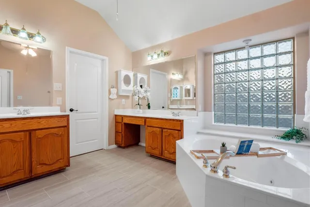 a bathroom with a granite countertop sink mirror bathtub and double