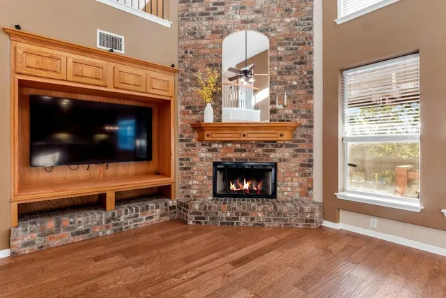 a living room with a fireplace a flat screen tv and a window