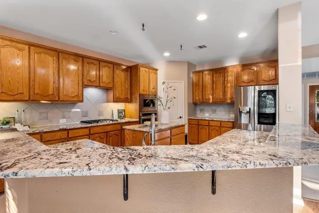 a kitchen with stainless steel appliances granite countertop sink stove and refrigerator