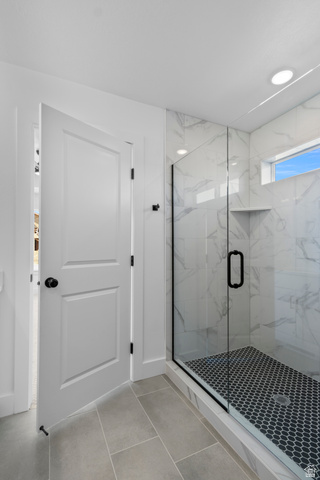 248 West 2920th Street South Logan, UT 84321 - Photo 31 of 47 Glass-enclosed shower with black hexagon tile flooring and white marble-look wall tiling