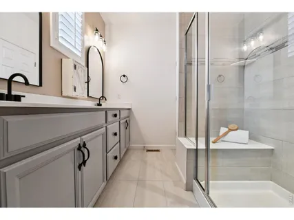 a bathroom with a double vanity sink a mirror and a shower