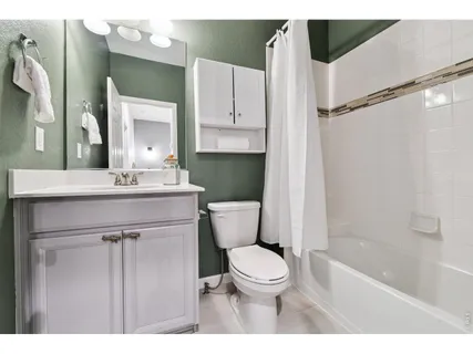a bathroom with a sink a toilet a mirror and shower