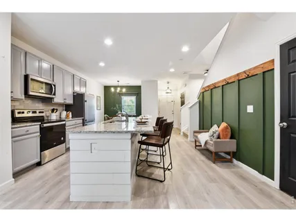 a kitchen with a table chairs refrigerator and cabinets