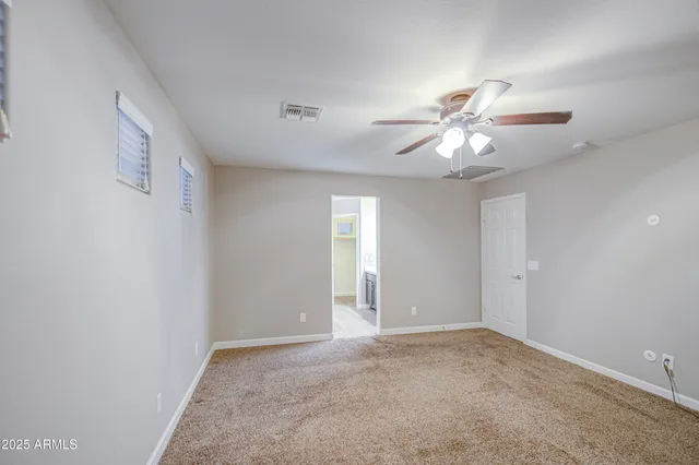 wooden floor in an empty room with a chandelier fan