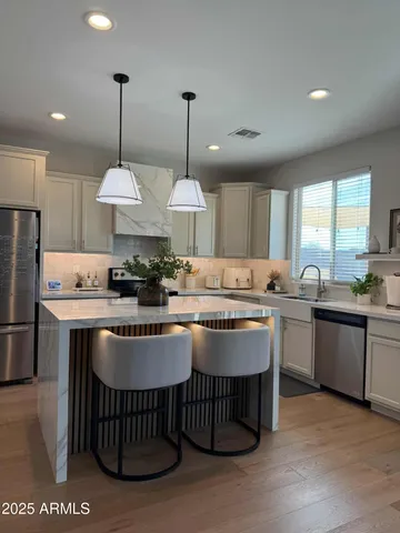 a kitchen with kitchen island granite countertop a stove a sink a center island and a refrigerator