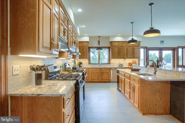 a kitchen with granite countertop cabinets stainless steel appliances a sink and a window