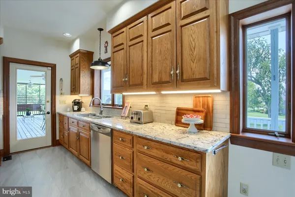 a bathroom with a granite countertop toilet a sink and mirror