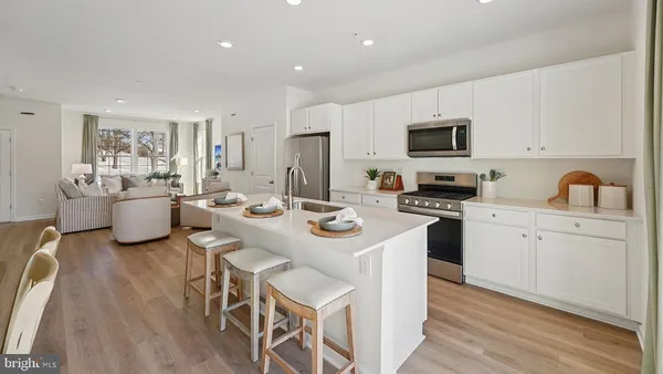 a kitchen that has a sink and a stove with white cabinets