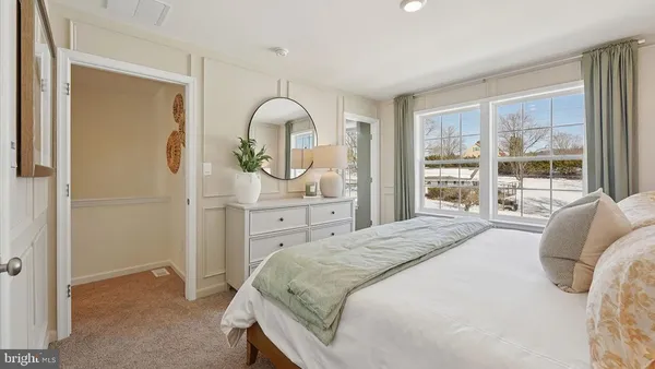 a spacious bedroom with a bed and a dresser