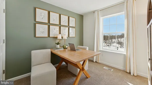 a view of a workspace with furniture and a window