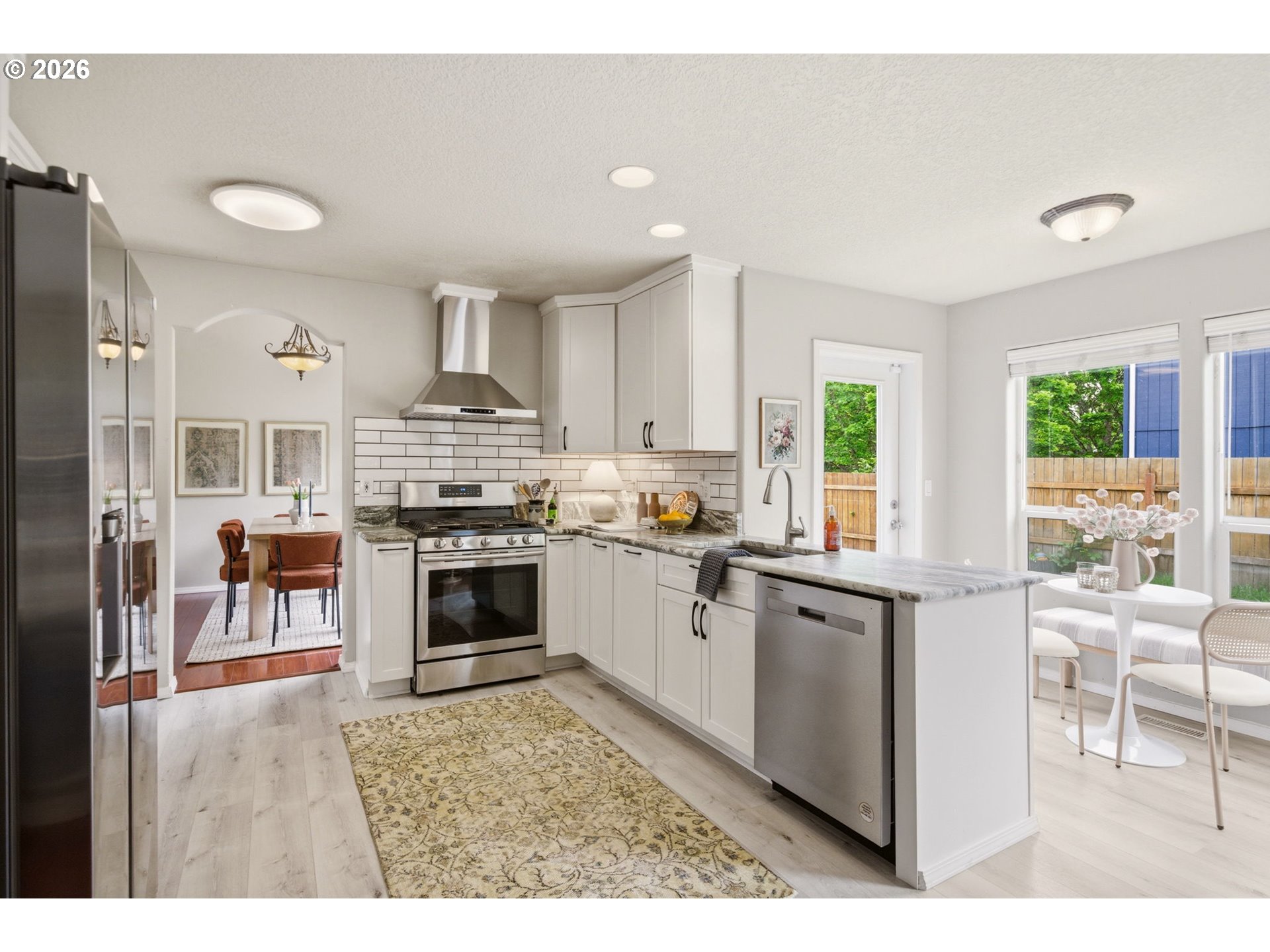 1448 Southwest 208th Avenue Beaverton, OR 97003 - Photo 13 of 39 a kitchen with stainless steel appliances granite countertop a stove top oven a sink dishwasher a dining table and chairs