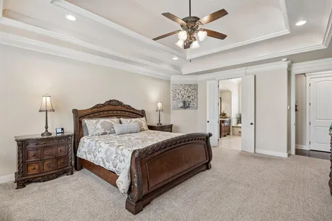 a bedroom with a bed and large windows