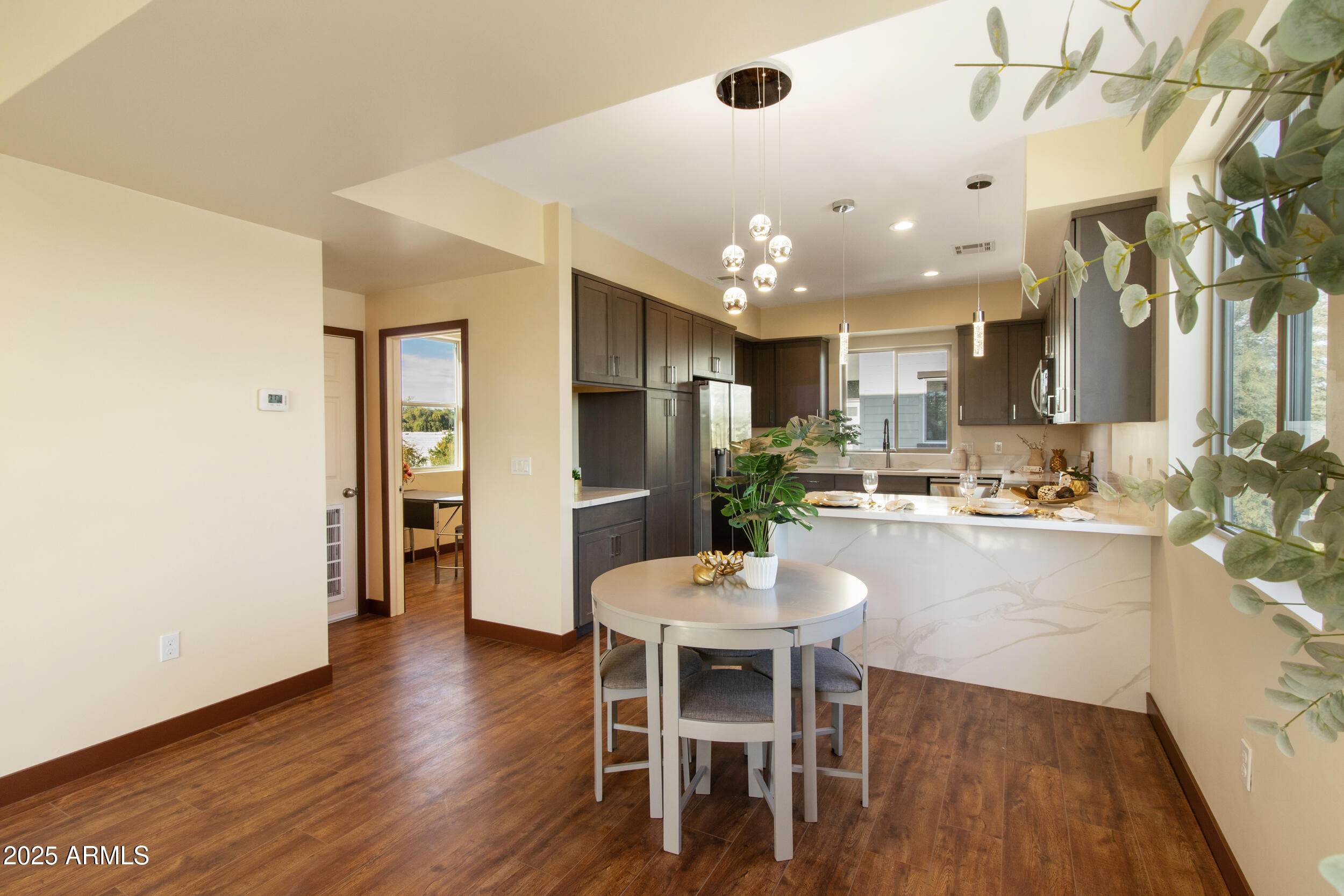 2014 West Lawrence Road Phoenix, AZ 85015 - Photo 11 of 24 a kitchen with a dining table chairs refrigerator and wooden floor