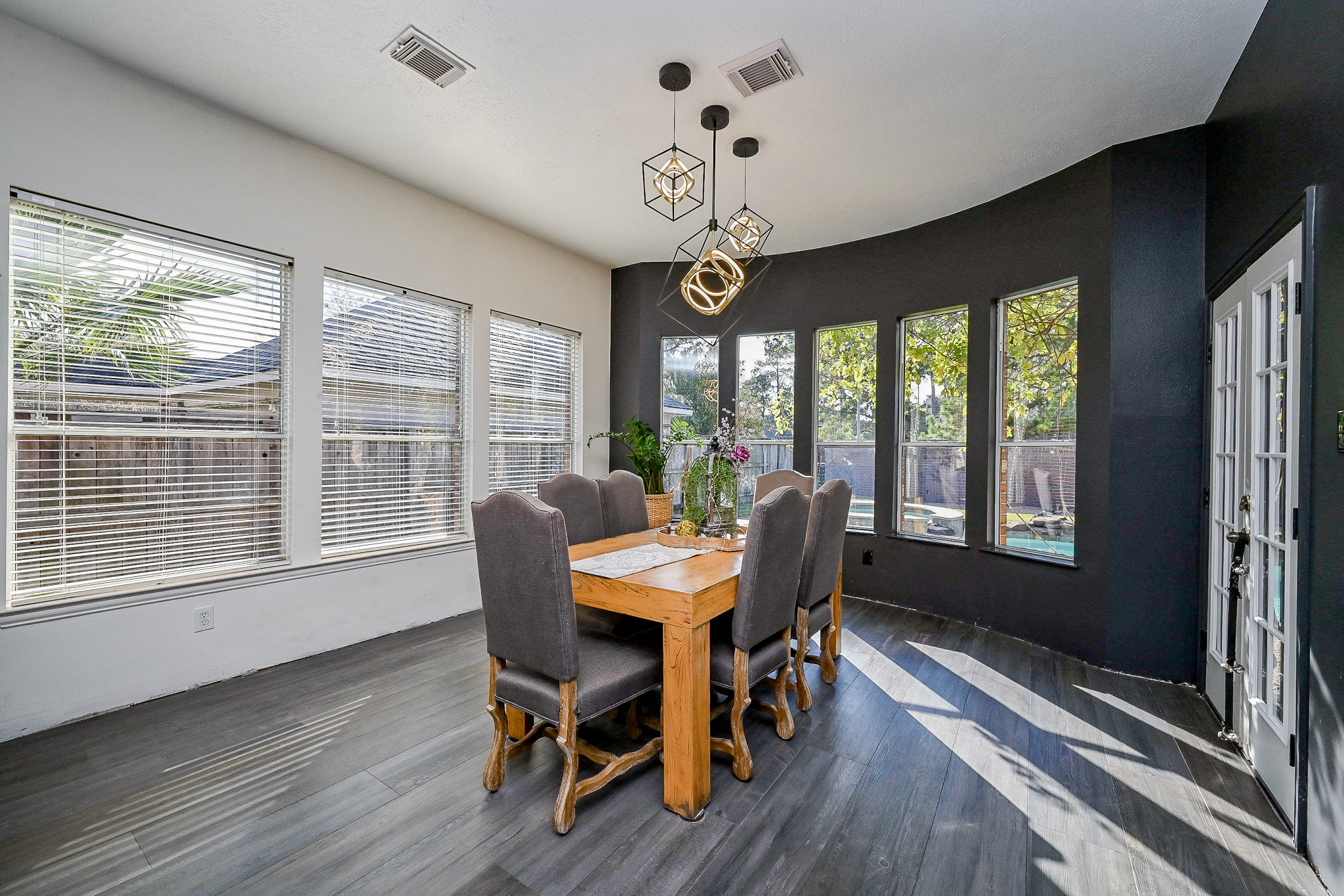 1331 Bishops Pl Drive Spring, TX 77379 - Photo 13 of 31 a dining room with wooden floor a chandelier a wooden table and chairs
