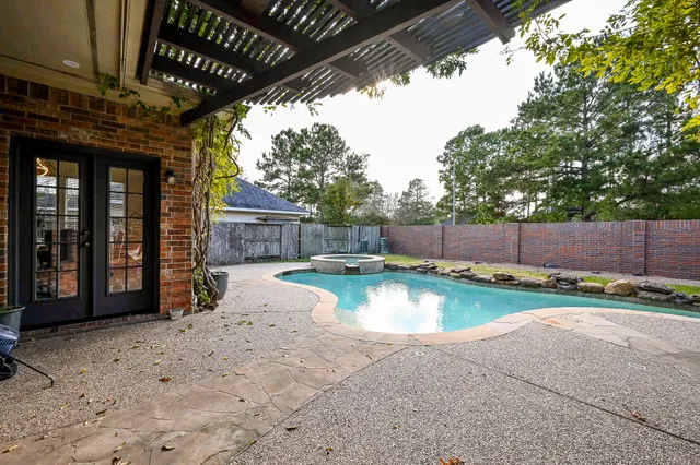 a view of a backyard with swimming pool and sitting area