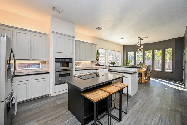 a kitchen with kitchen island wooden cabinets and stainless steel appliances