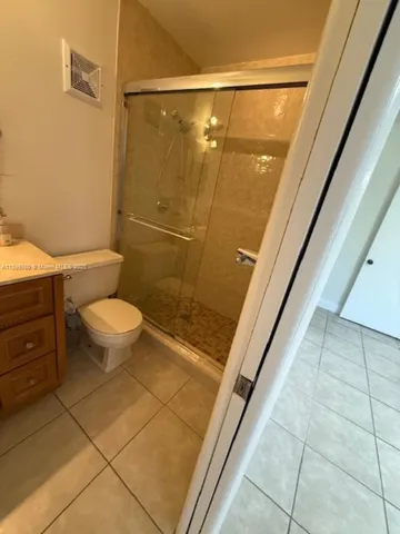 a bathroom with a granite countertop sink a toilet and shower
