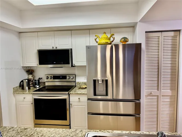 a kitchen with stainless steel appliances granite countertop a sink and cabinets