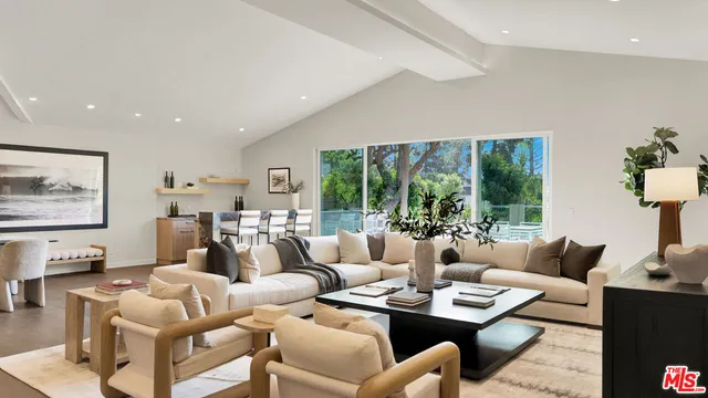 a spacious bedroom with a bed a couch and a large window