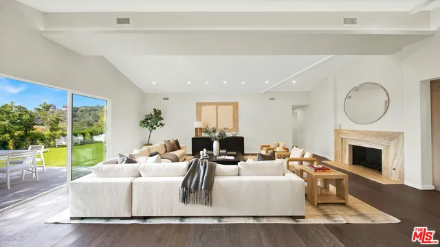 a kitchen with stainless steel appliances a dining table chairs refrigerator and sink