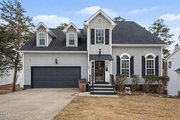a front view of a house with yard and parking