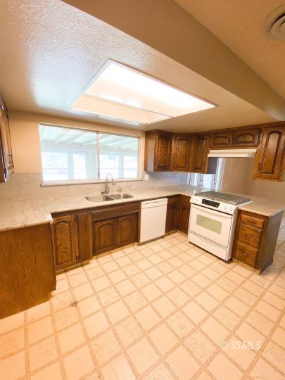 516 West Wasp Avenue Ridgecrest, CA 93555 - Photo 5 of 25 a kitchen with stainless steel appliances a stove a sink and white cabinets