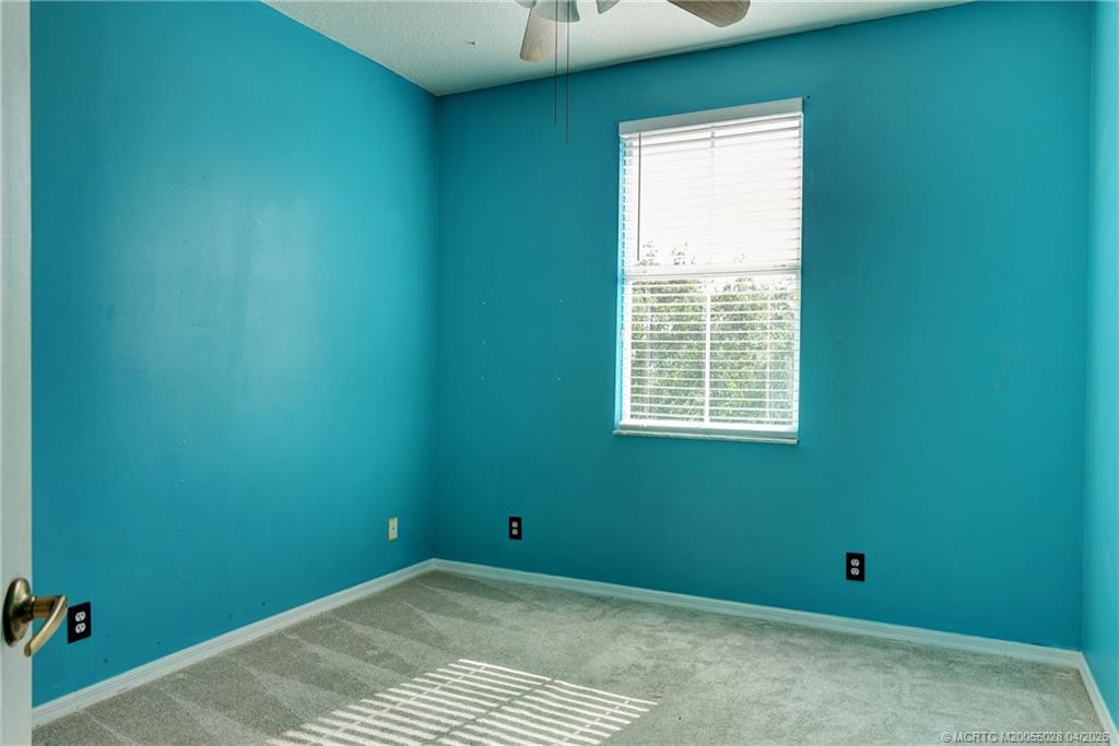 2120 Northwest Marsh Rabbit Lane Jensen Beach, FL 34957 - Photo 32 of 34 a view of an empty room with a window and a ceiling fan