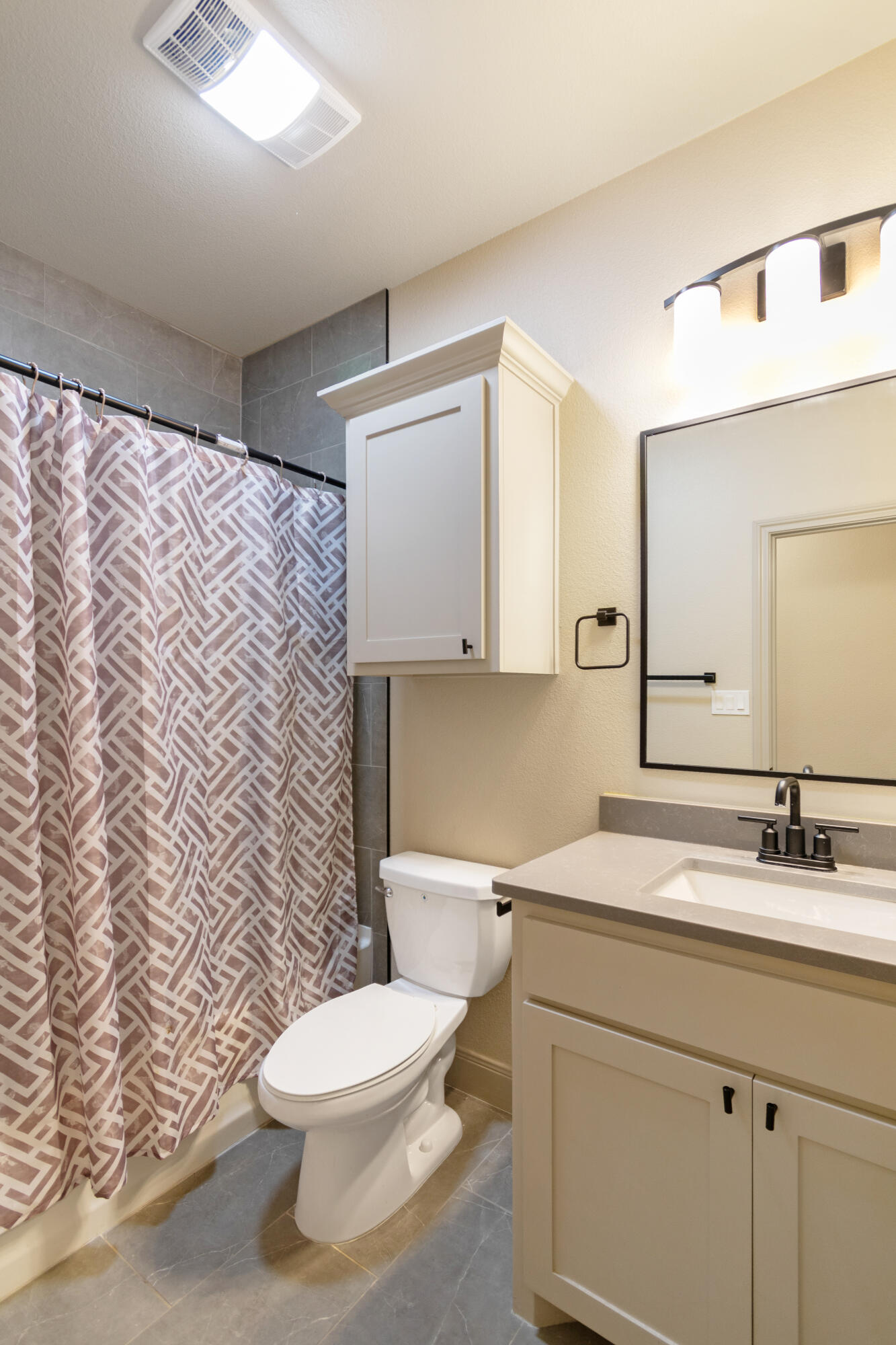 2802 134th Street Lubbock, TX 79423 - Photo 16 of 27 a bathroom with a granite countertop toilet sink and mirror