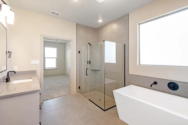 a bathroom with a tub sink shower and mirror