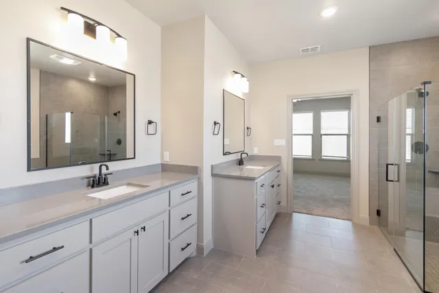 a spacious bathroom with double sink and a mirror