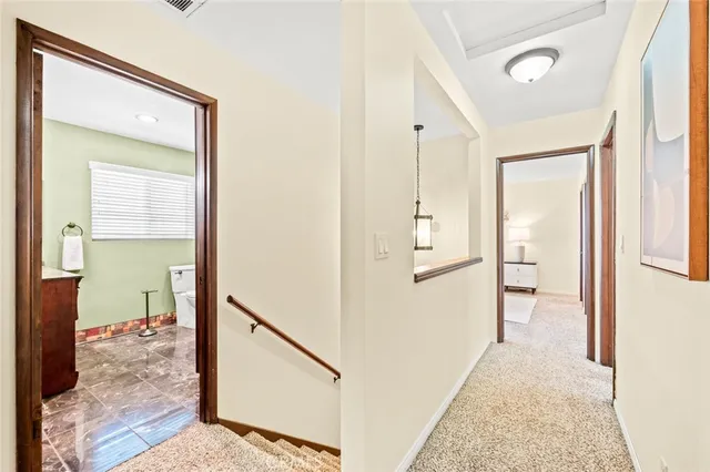 a view of a hallway with wooden floor and a living room