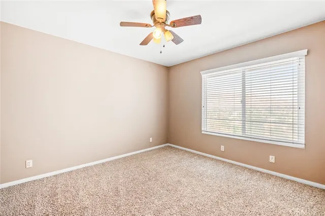 an empty room with a window and a fan