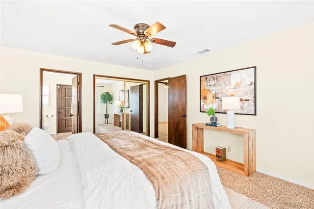 a bedroom with a large bed and a chandelier