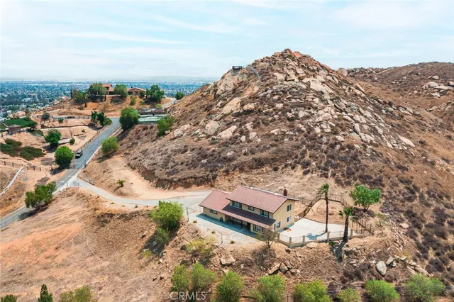 an aerial view of a house with a yard and mountain view in back