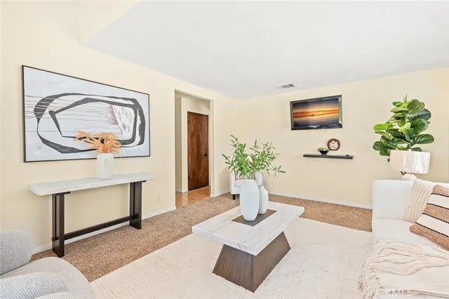a living room with furniture a potted plant and a fireplace
