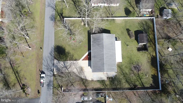 a view of a white house with a yard and a large tree