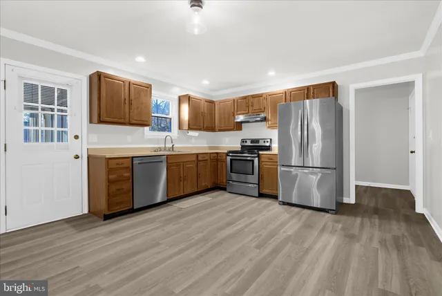 a kitchen with stainless steel appliances a refrigerator and a stove top oven
