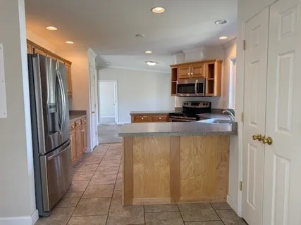 a kitchen with stainless steel appliances granite countertop a refrigerator and a stove top oven