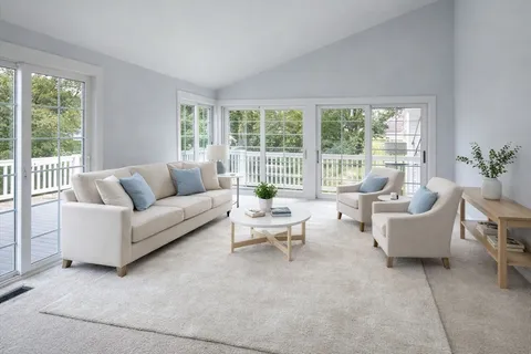 a living room with furniture and floor to ceiling windows