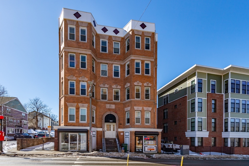 301-305 Dudley Street Boston, MA 02119 - Photo 1 of 14 a front view of a building with lot of cars and trees