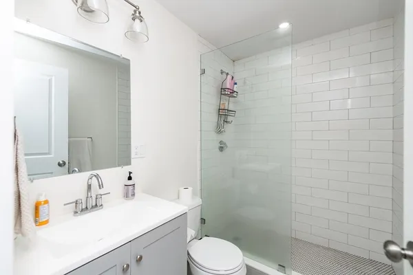 a bathroom with a sink a toilet and shower