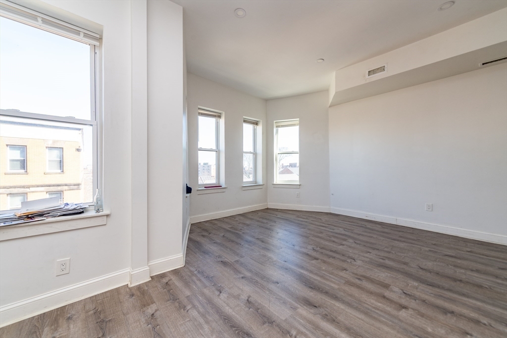 301-305 Dudley Street Boston, MA 02119 - Photo 12 of 14 a view of an empty room with wooden floor and a window