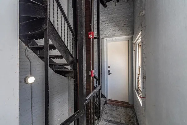 a view of hallway with stairs and wooden floor