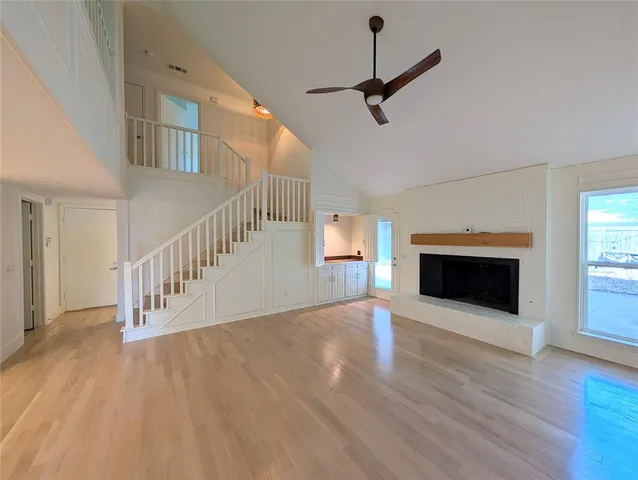 a view interior of a house with wooden floor a fireplace and windows