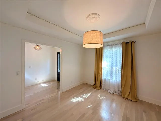 an empty room with wooden floor and mirror