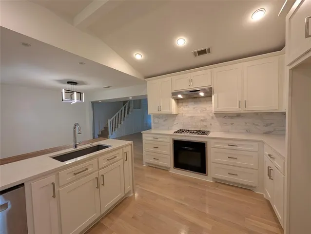 a kitchen with white cabinets and white appliances